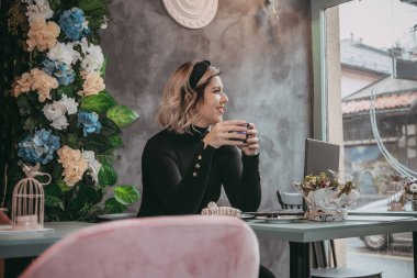 Dizüstü bilgisayar ve içecek kahve yazarak kız