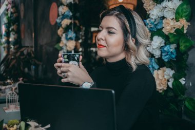 Dizüstü bilgisayar ve içecek kahve yazarak kız