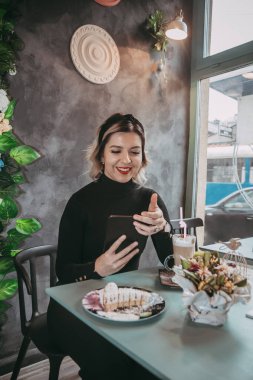 Dizüstü bilgisayar ve içecek kahve yazarak kız