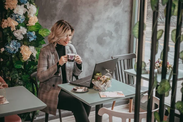 Dizüstü bilgisayar ve içecek kahve yazarak kız