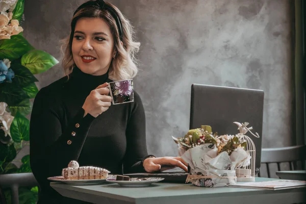 Dizüstü bilgisayar ve içecek kahve yazarak kız