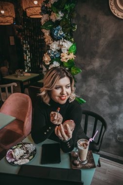 Dizüstü bilgisayar ve içecek kahve yazarak kız