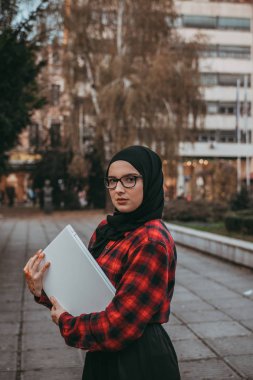 Dizüstü bilgisayarda yazarak genç Müslüman kız 