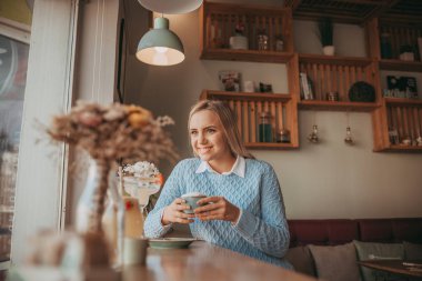 Genç gril kek ve kahve içmek beyaz yemek