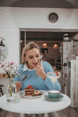 Genç gril kek ve kahve içmek beyaz yemek