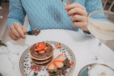 Genç gril kek ve kahve içmek beyaz yemek