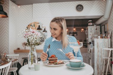 Genç gril kek ve kahve içmek beyaz yemek