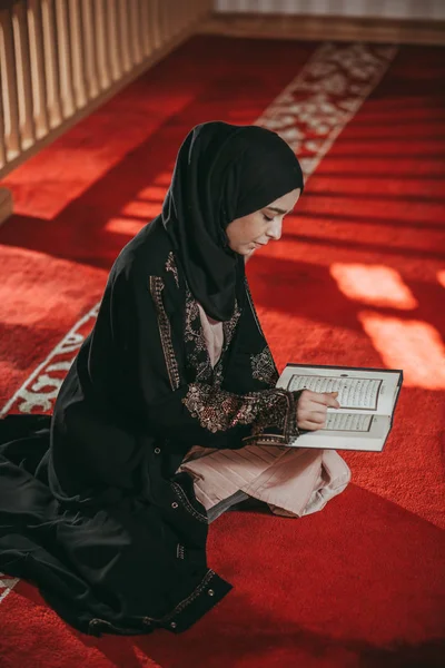 Jovem garota muçulmana lendo um livro sagrado — Fotografia de Stock