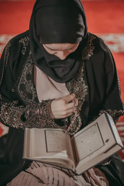 Jovem garota muçulmana lendo um livro sagrado — Fotografia de Stock