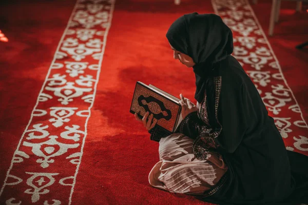 年轻的穆斯林女孩读一本圣书 图库图片