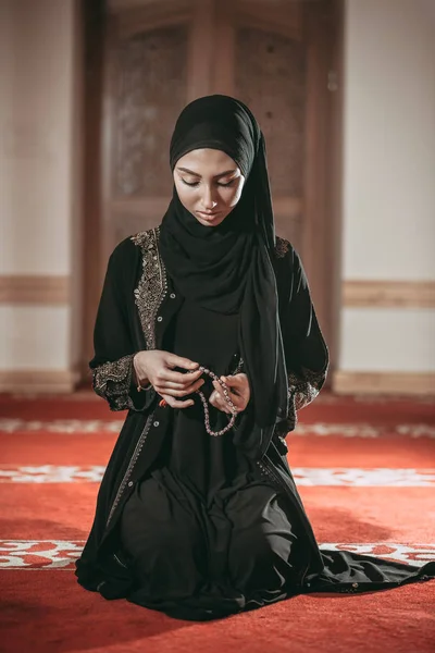 Young muslim woman pray in mosque