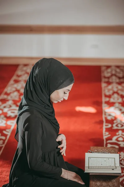 Muslim woman reading Quran in mosque