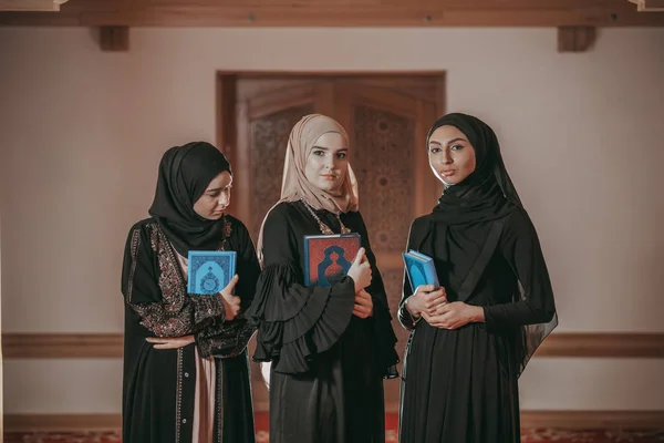 Three muslim girls reading Quran in mosque