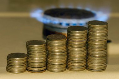Gaz fiyat kavramında artış. Mavi gaz alev ve sikke artan yığını.