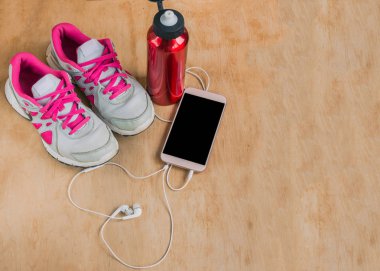 Spor ayakkabı, şişe su, ahşap zemin üzerinde müzik çalarla ile.