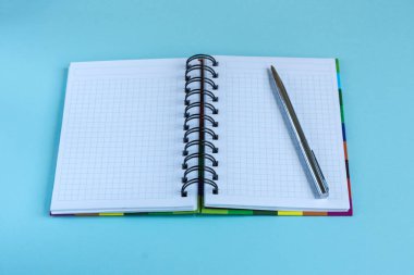 Açık boş defter ve renk pastel arka plan üzerindeki metinlere mockup olarak gümüş kalem.