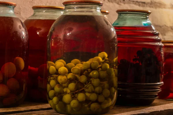 Bodega, ciruelas, manzanas, uva en un frasco, jugo dulce — Foto de Stock