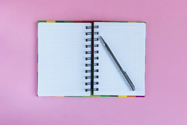 Open blank notebook and a silver pen as a mockup to text on color pastel background. — Stock Photo, Image