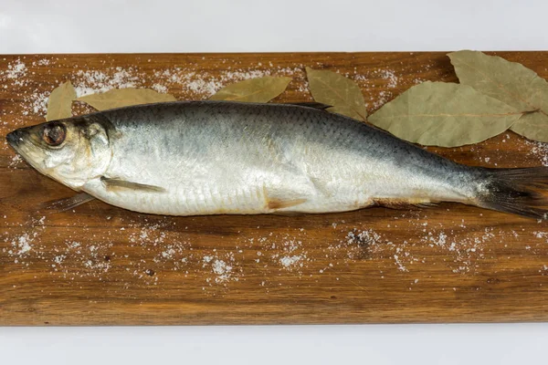 Tasty herring. Salty fish top view on the wood.