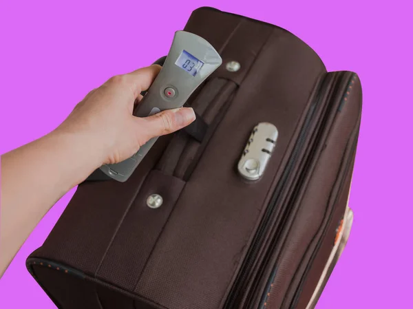 Hand of woman holding digital luggage scales. Avoid baggage overweight in airport concept. — Stock Photo, Image