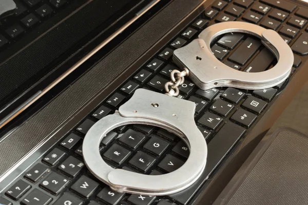 Computer keyboard and handcuffs top view. — Stock Photo, Image