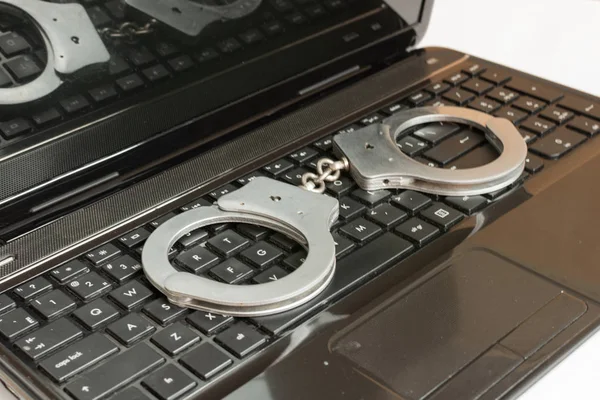 Computer keyboard and handcuffs top view. — Stock Photo, Image