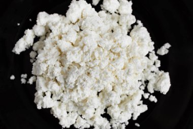 Siyah tabak üst görünümünde köy peyniri.