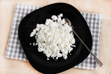 Siyah tabak üst görünümünde köy peyniri.