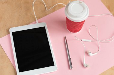 Tablet ile kulaklık ile boş siyah perde ve bir fincan kahve üst görüntüleme.