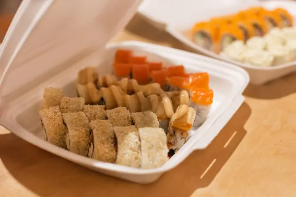 Sushi rolls  in a white plastic lunch box takeaway. — Stock Photo, Image