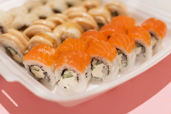 Sushi rolls  in a white plastic lunch box takeaway. — Stock Photo, Image