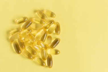 Sarı arka plan üzerinde balık yağı vitaminleri Omega3 Kapsüller.