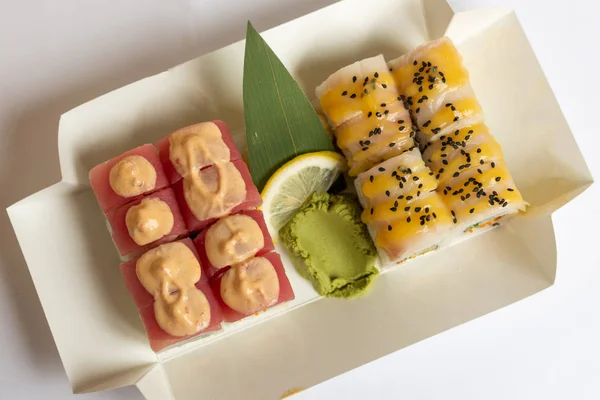 Sushi rolls  in a white eco paper lunch box takeaway.