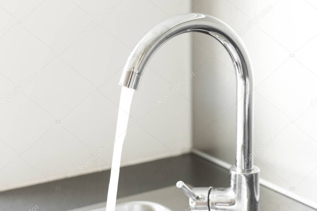 Mixer tap with water flowing.