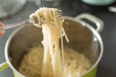 Tavada bir çatal asılı Haşlanmış spagetti.
