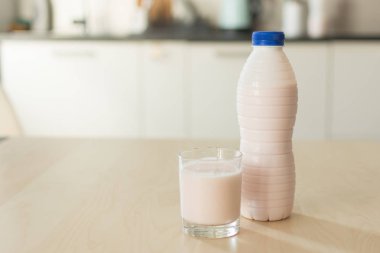 Mutfak iç ahşap masa arka plan üzerinde şişe ve yoğurt cam.