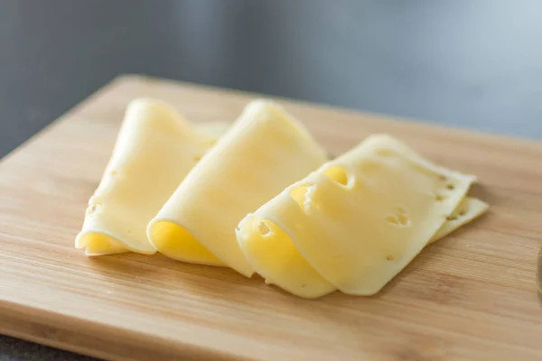 Fatias de queijo no fundo de madeira . — Fotografia de Stock