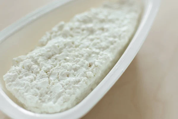 Коттеджный сыр в белой миске крупным планом . — стоковое фото