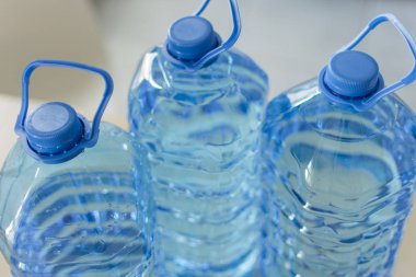 Parlak mutfak backgroung üzerinde masada su ile büyük plastik şişe.