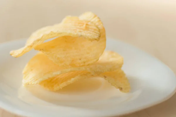 Kartoffelchips in Plättchen auf einem hölzernen Hintergrund Draufsicht. — Stockfoto