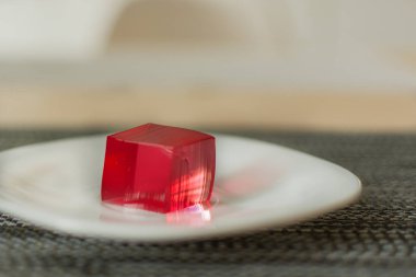 Beyaz plaka arka planda kırmızı jöle küpleri.