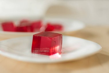 Beyaz plaka arka planda kırmızı jöle küpleri.