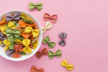 İtalyan ham çok renkli farfalle makarna yakın çekim pembe arka plan üzerinde bir kase.