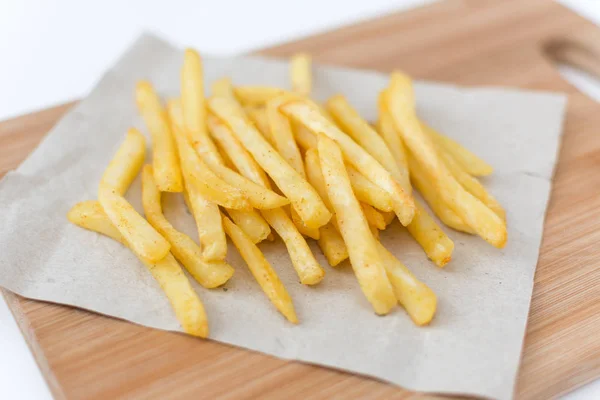 French fried potatoes on cutting board top view. — Stock Photo, Image