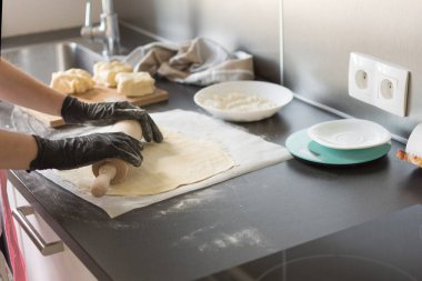 Kadın hamur işi için masaya yuvarlanıyor..