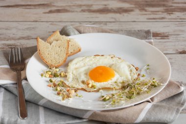 Sağlıklı kahvaltı. Kızarmış yumurta yakın filizlenmiş tahıl ile servis.