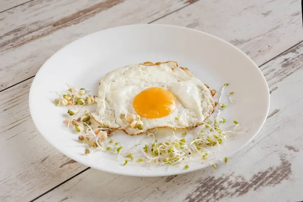 Sağlıklı kahvaltı. Kızarmış yumurta yakın filizlenmiş tahıl ile servis.