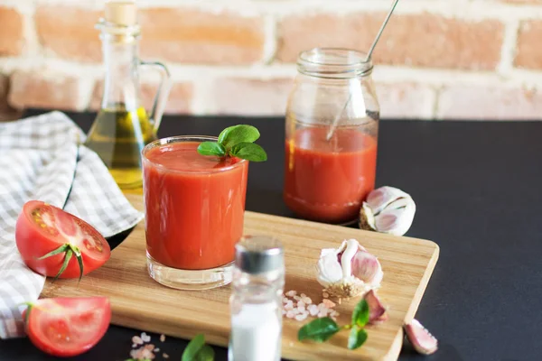 Sumo de tomate em um copo e tomates frescos na mesa de madeira . — Fotografia de Stock