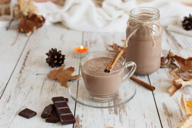 Ahşap arka planda marshmallow ve tarçın ile sıcak çikolata kakao içecek.