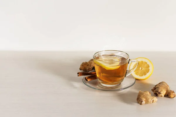 Filiżanka gorącej herbaty z imbirem, cytryną i cynamonem na białym tle. — Zdjęcie stockowe